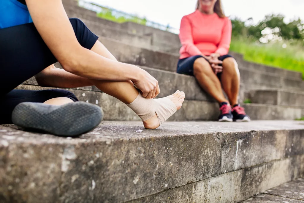 woman wrapping foot in bandage 2023 11 27 05 19 10 utc